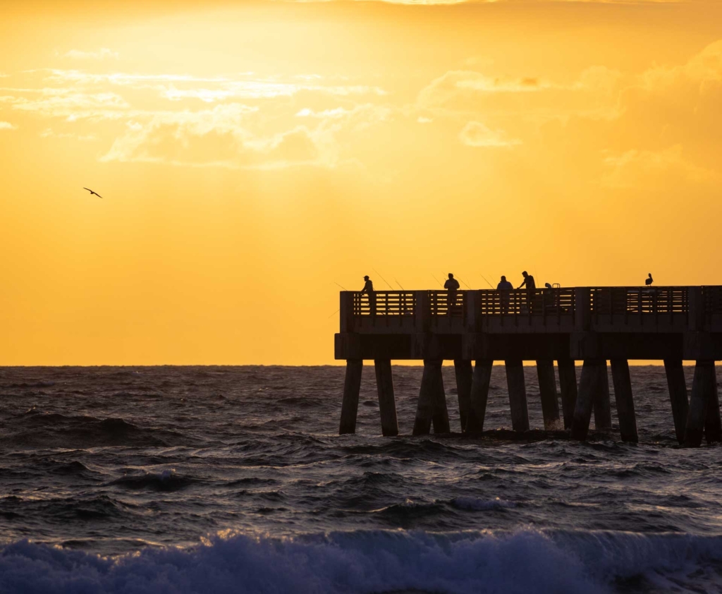 Lake Worth Beach pier with fishermen and sunset